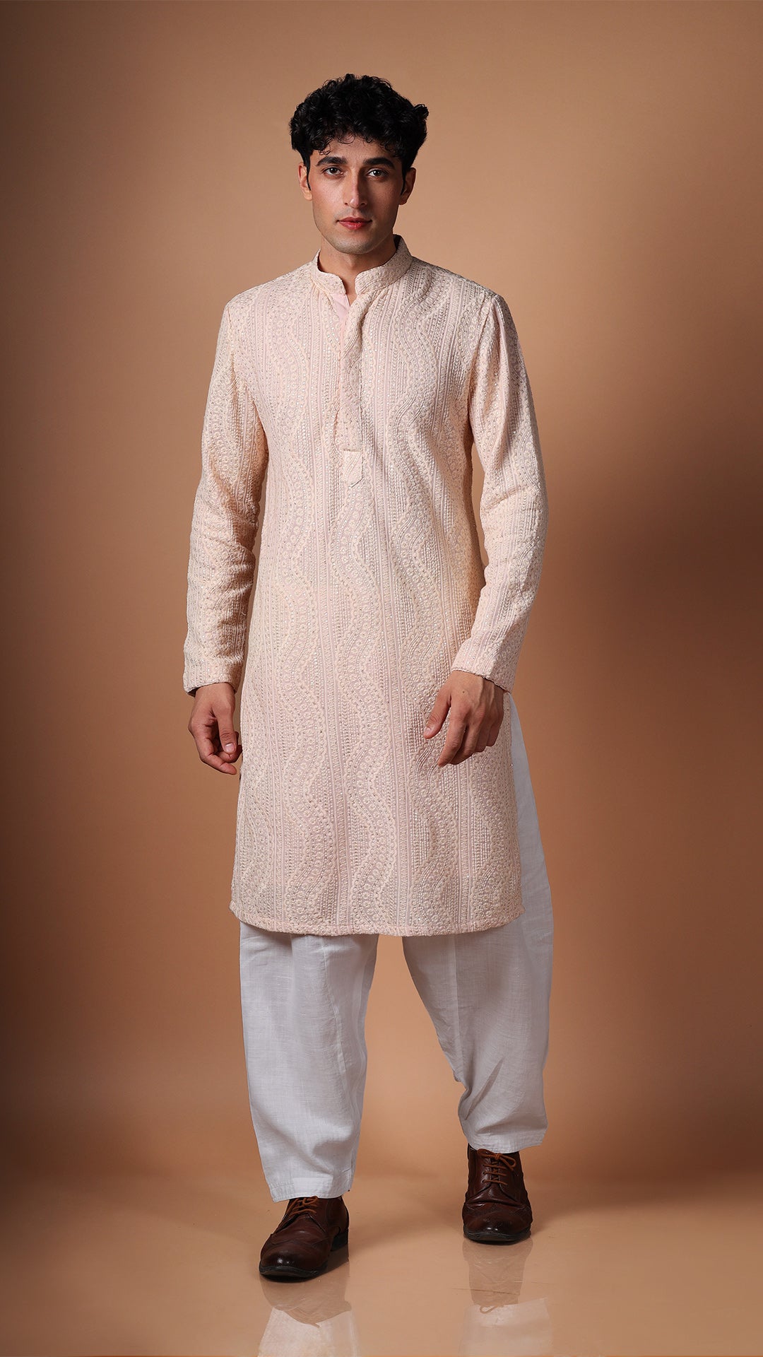 Different angle of Peach Kurta, showcasing dense sequin and mirror patterns. Paired with salwar and tan Oxford shoes.