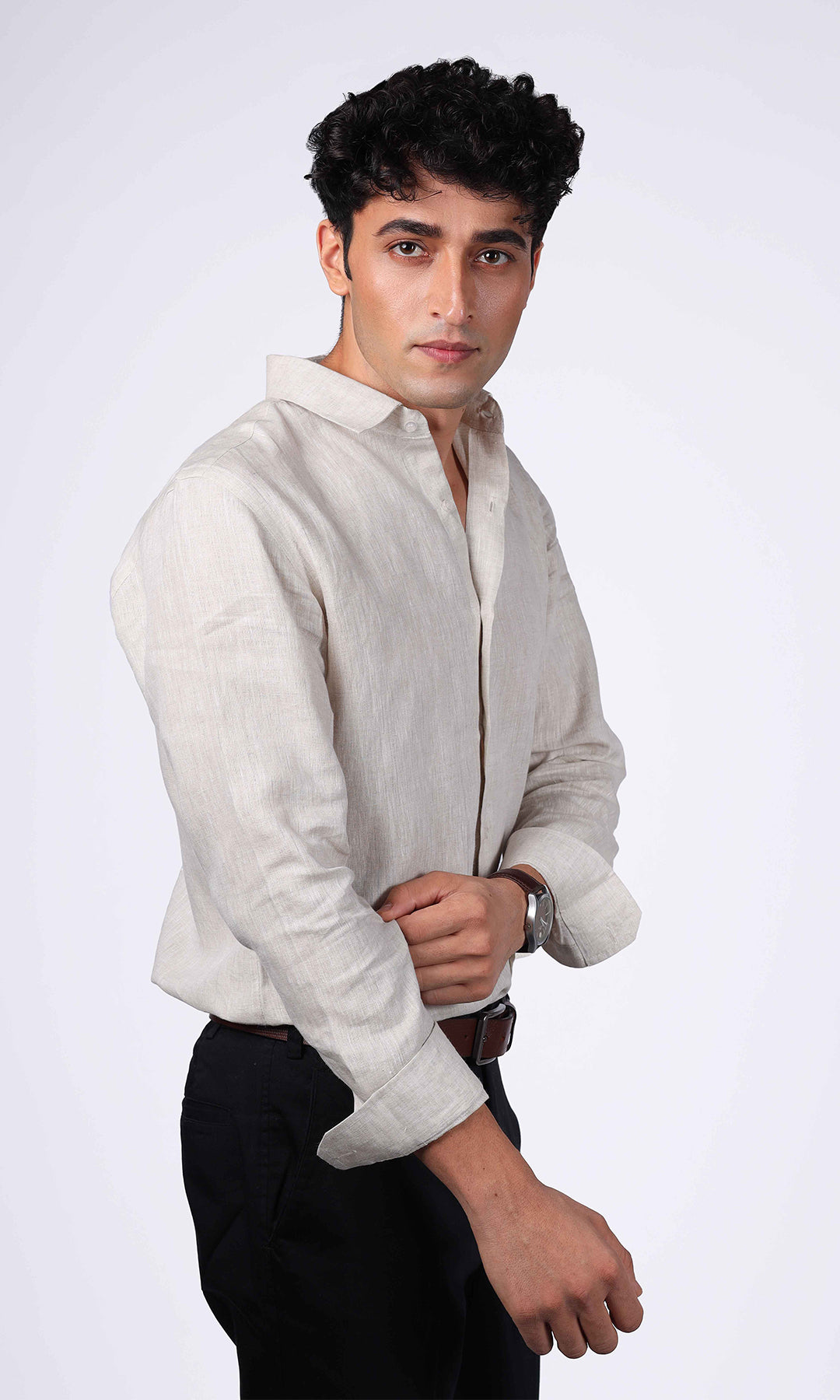 Side profile of a model in a beige linen shirt, emphasizing the shirt's tailored fit