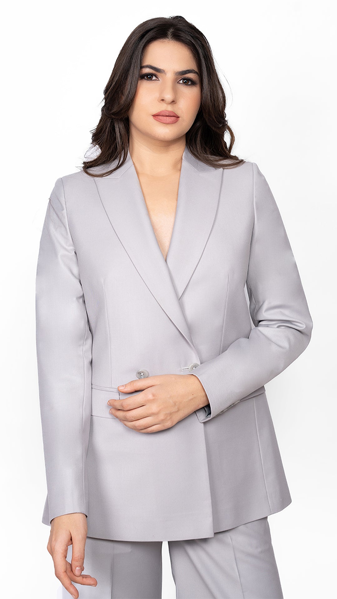 A tailored light grey blazer featuring a sleek peak lapel and a structured double-breasted 2-button closure. A perfect balance of elegance and authority