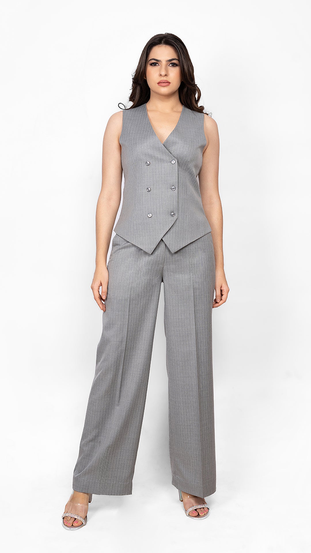 A polished and structured waistcoat-and-trouser set in classic grey pinstripes, designed for women who want to make a confident statement.