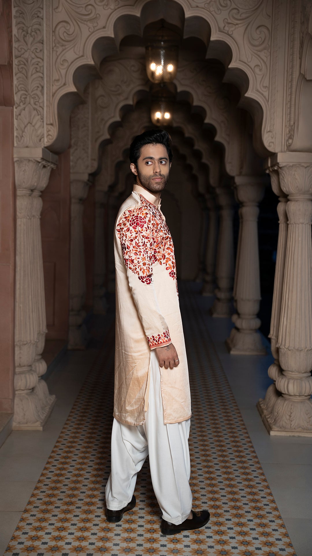 Man in traditional outfit standing in an ornate archway