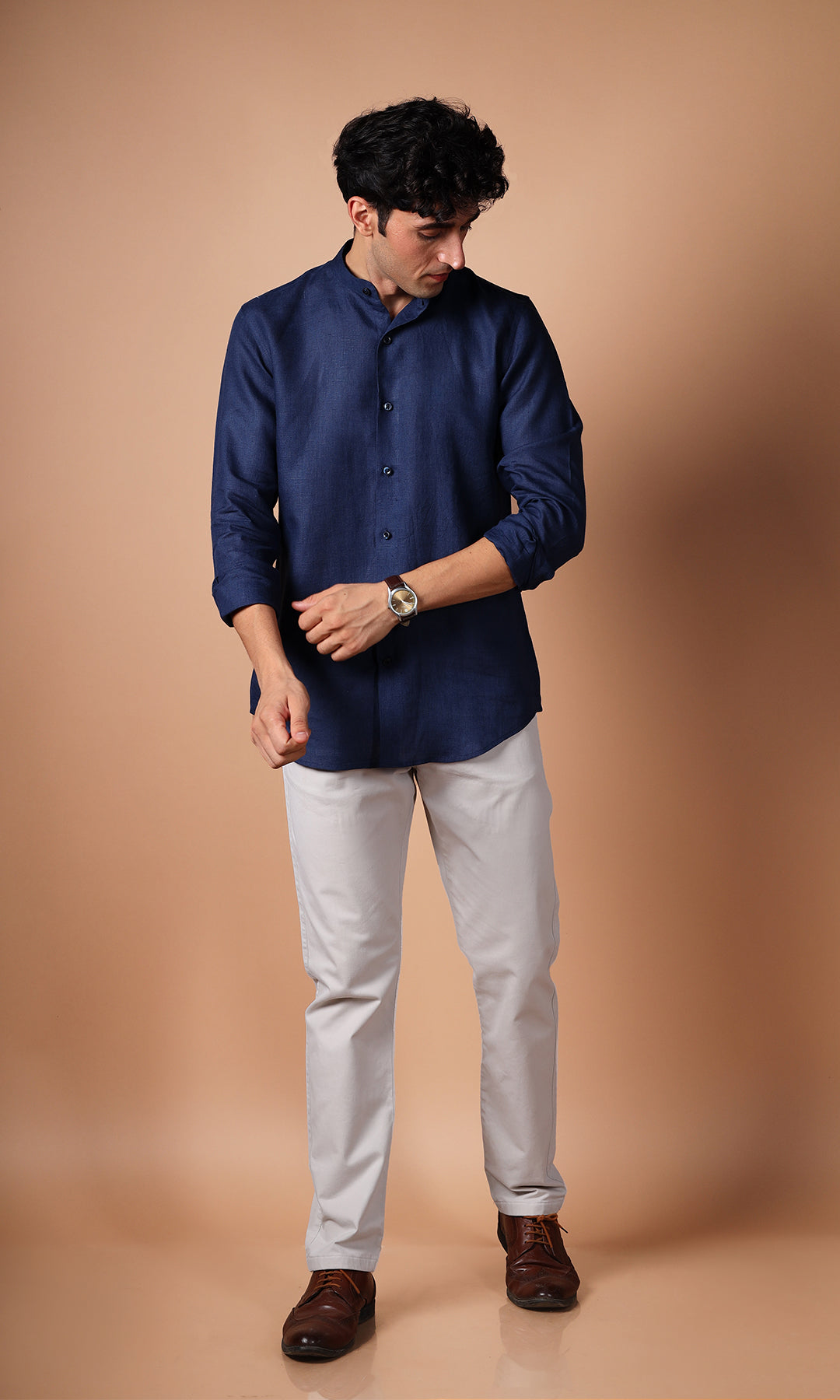 Model in a navy blue linen shirt from the side, highlighting the shirt’s tailored elegance