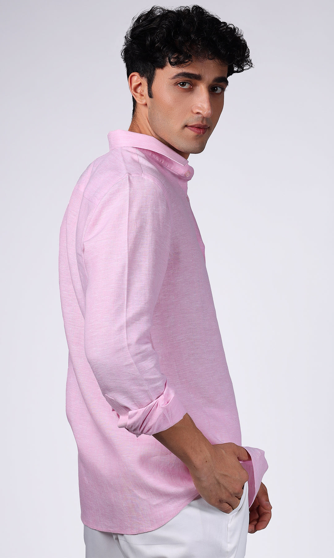 Model posing in a pink linen shirt, styled for a vibrant and youthful appearance.