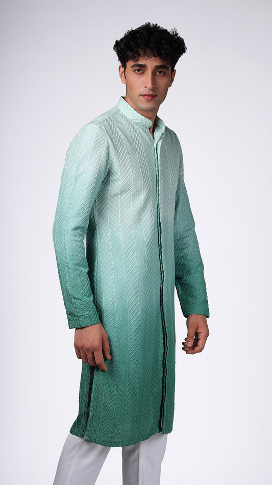 Close-up of Green Ombre Kurta with Bamboo Embroidery, highlighting intricate details. Model paired with white slim trousers