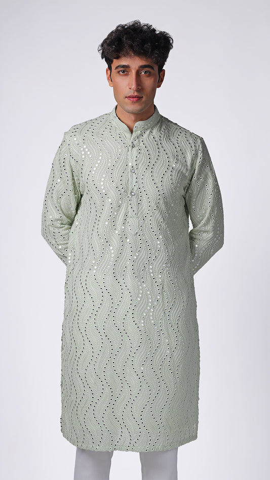 Detailed view of Mint Green Kurta, highlighting patterned mirror embroidery. Model styled with white slim trousers