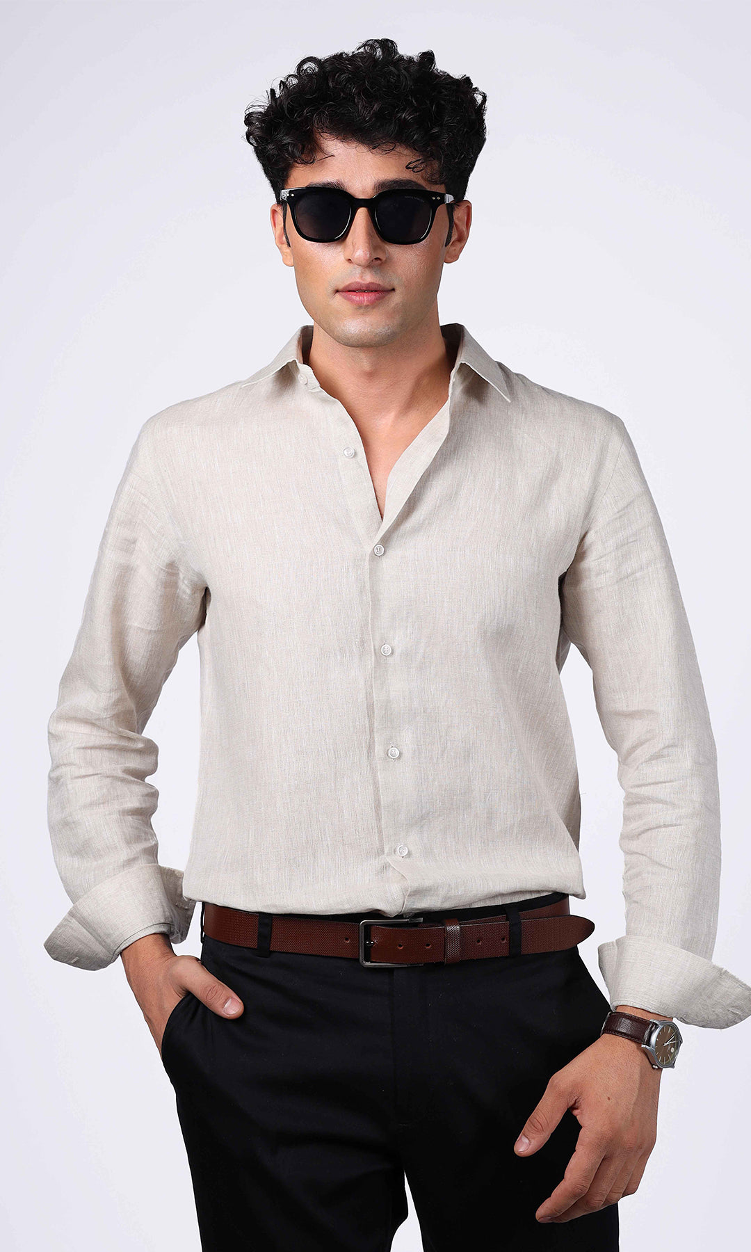 Front view of a beige linen shirt on a model, styled with a clean and smart look.