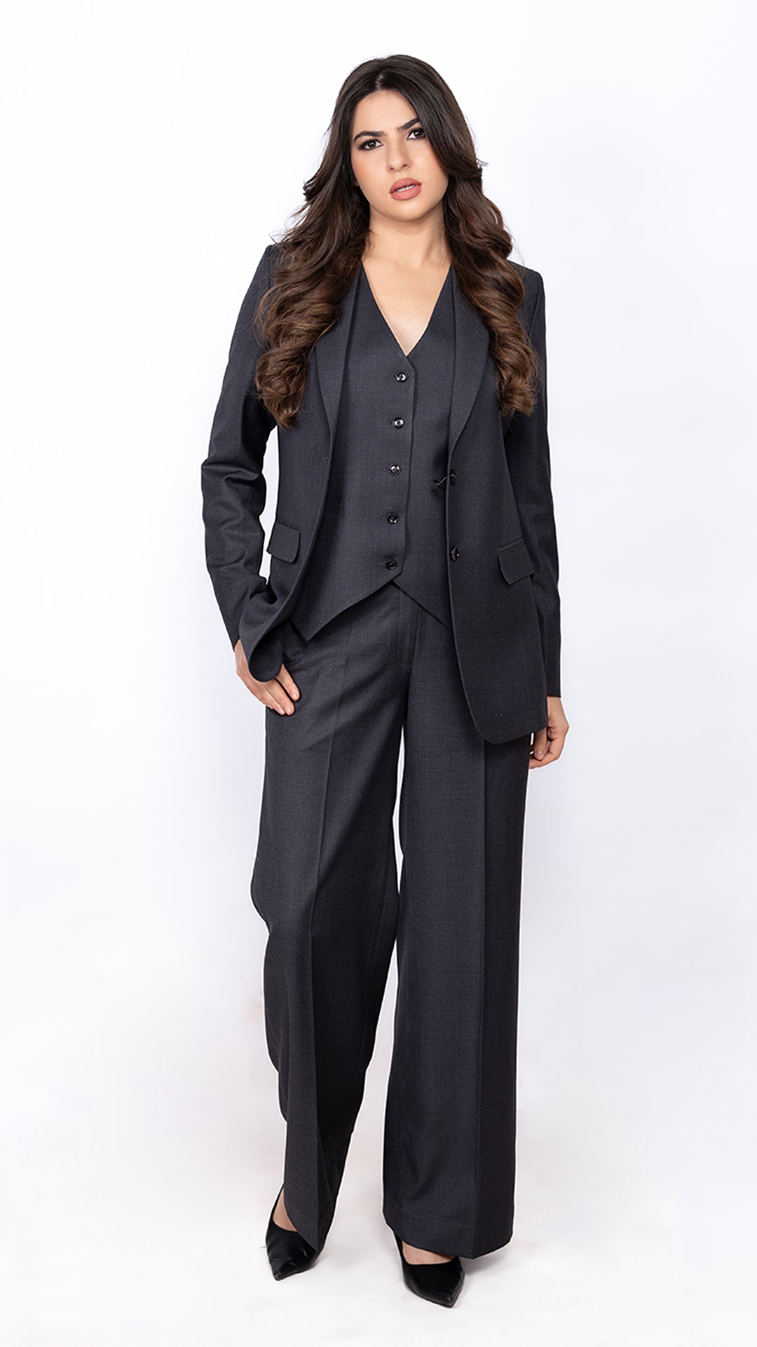 Impeccably tailored dark grey suit for women, including a blazer, waistcoat, and trousers. A modern take on classic formal wear.