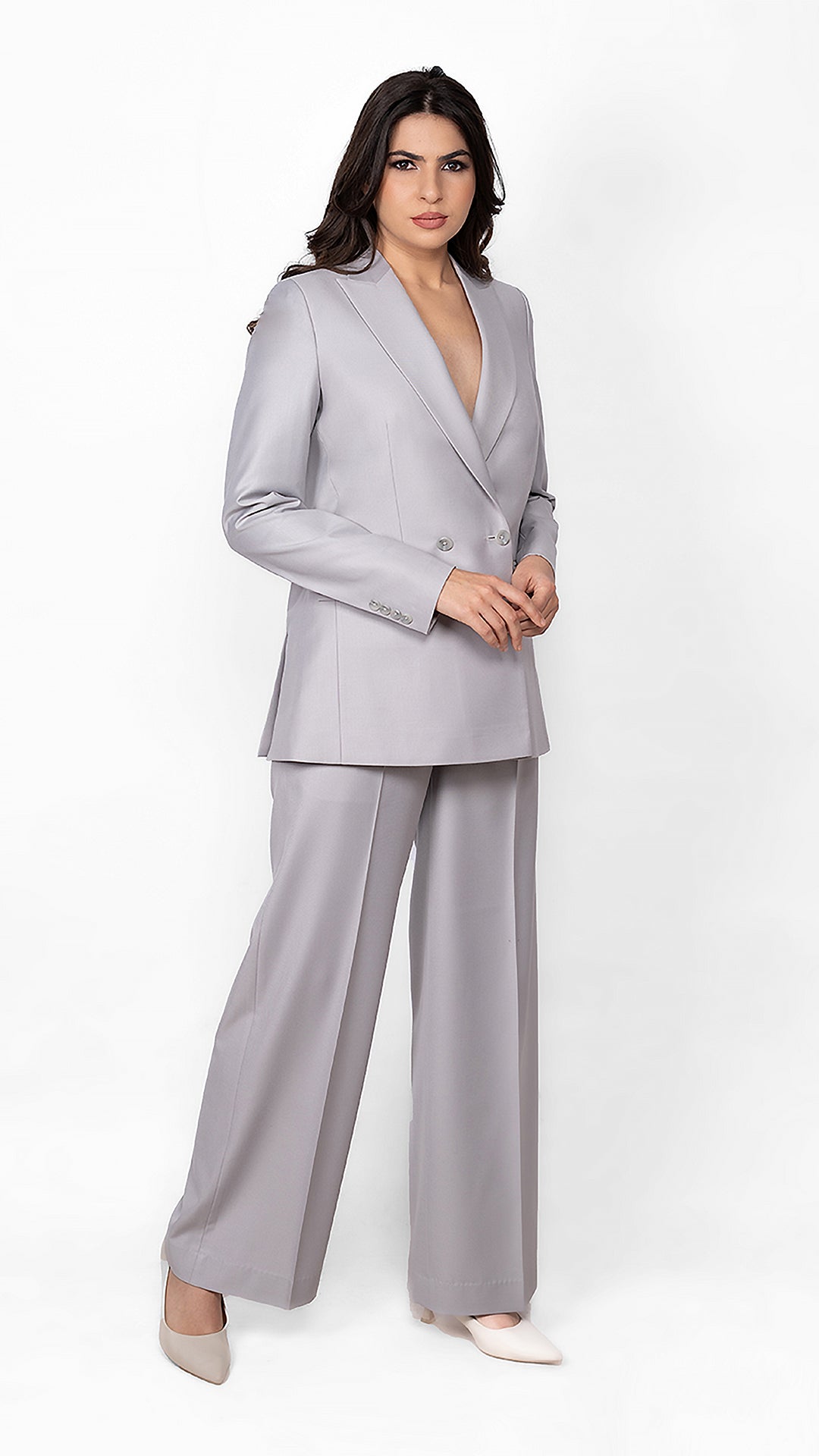 A soft yet bold light grey suit featuring a precisely tailored blazer and trousers, ideal for a strong yet feminine aesthetic.
