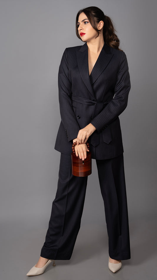 A sophisticated blue pinstriped suit with a structured blazer, peak lapel, and waist belt, paired with sleek tailored trousers.