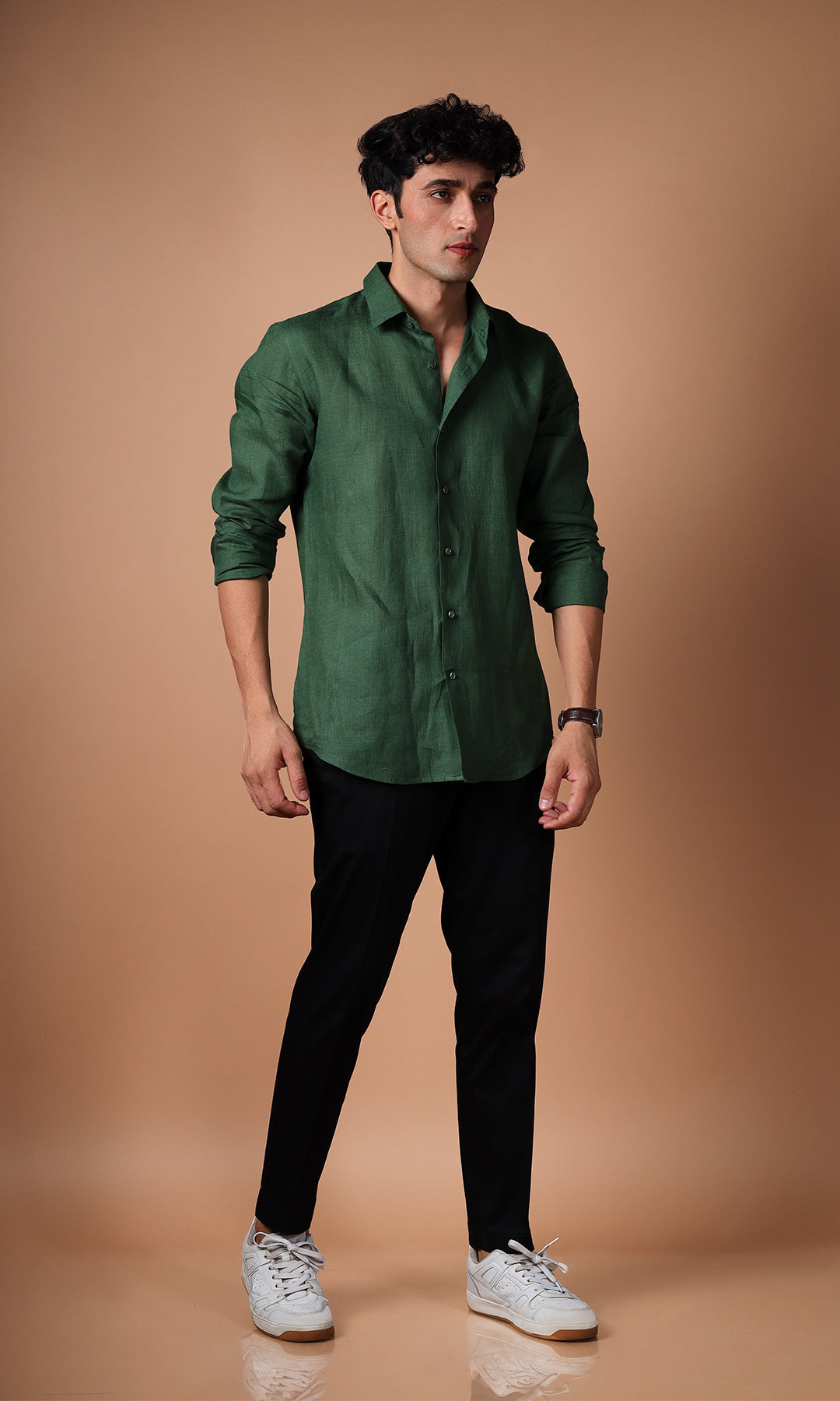 Model in an olive green linen shirt, standing in a confident pose, styled for versatility.