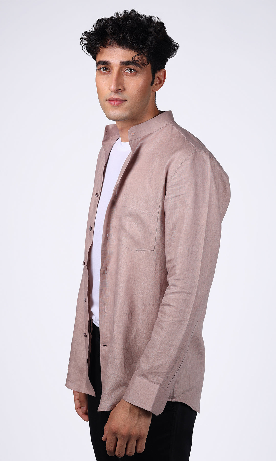 Side profile of a model in a pink linen overshirt, illustrating how it drapes casually over a basic tee, enhancing the outfit’s casual chic vibe
