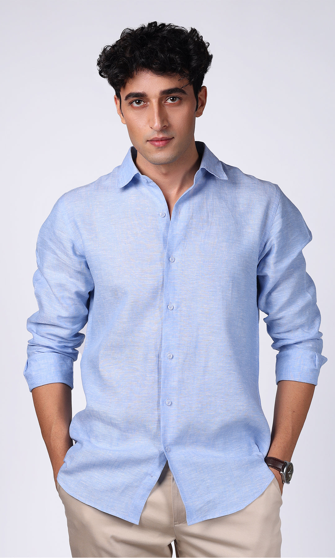 Front view of a model wearing a sky blue linen shirt, showing off a classic and clean look