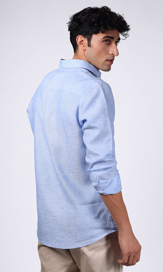 Model in a sky blue linen shirt seen from the side, emphasizing the fit and drape of the fabric.