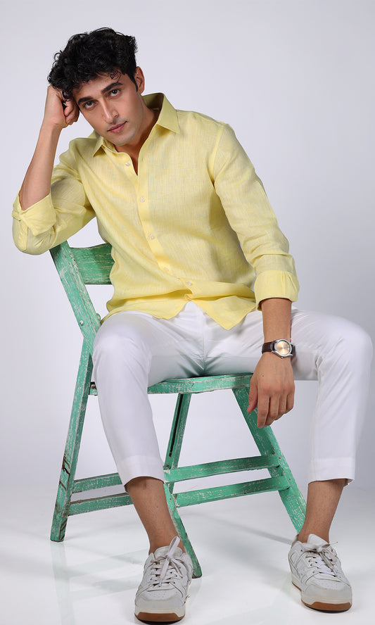 Relaxed pose of a model in a yellow linen shirt, illustrating a cheerful and lively style.