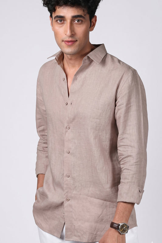 Greige pure linen shirt for men, three-quarter angle view with collar open and sleeves rolled, spread collar and chest pocket detail, styled with white trousers, by BWO