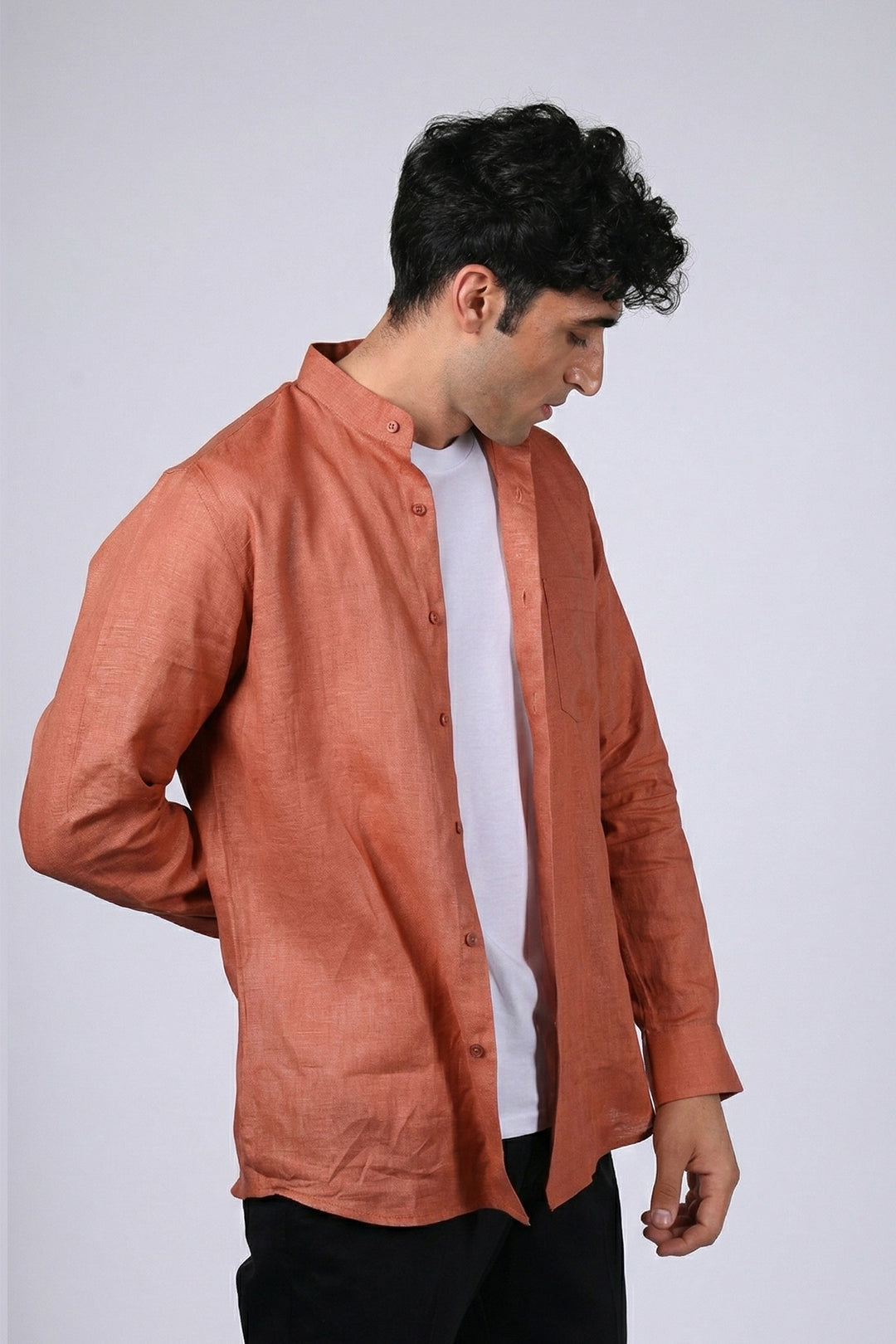 Rust pure linen shirt for men, side view worn open over white tee, band collar and long sleeves with buttoned cuffs, styled with black trousers, by BWO