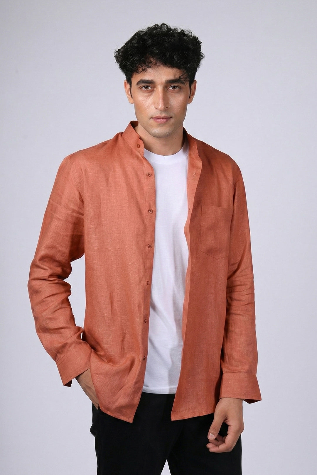 Rust pure linen shirt for men, front view worn open over white tee, band collar and chest pocket visible, styled with black trousers, by BWO