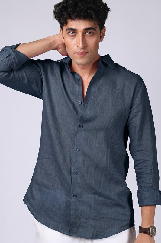 Steel blue pure linen shirt for men, front view with collar open and hand behind neck, spread collar and button placket detail, styled with white trousers, by BWO